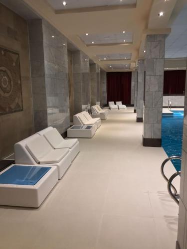 a waiting room with white couches and a pool at Status Hotel in Río Grande