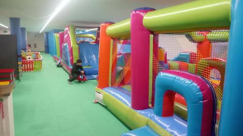 a child is playing in a play room with a playground at HOTEL LAGO in Villanueva de Arosa