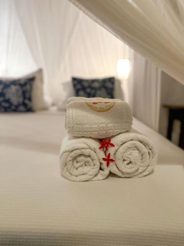 a stack of towels sitting on top of a bed at Casa da Glória Trancoso - Pousada Boutique in Trancoso