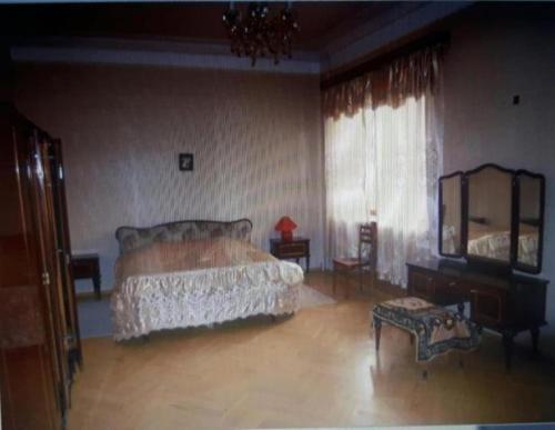 a bedroom with a bed and a table and a mirror at Guli in Gori