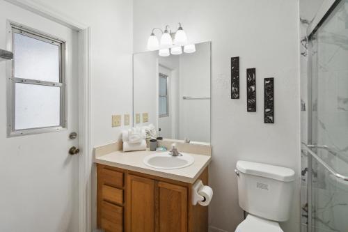 een badkamer met een wastafel, een toilet en een spiegel bij Bella Point View in Davenport