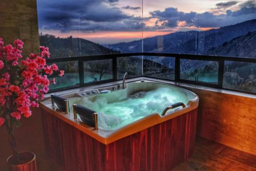 a bathroom with a tub with a view of a mountain at El Encanto Hotel Boutique in Duitama