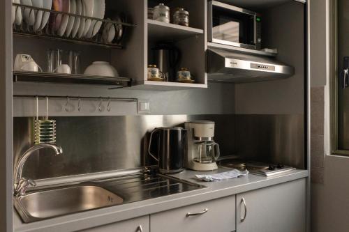 CENTRAL Studio - Fully equiped. Ideal for couples في باترا: مطبخ مع حوض وآلة صنع القهوة