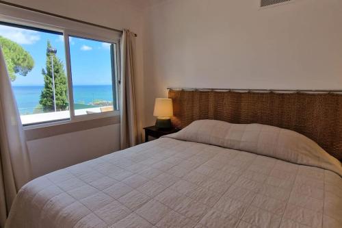 Schlafzimmer mit einem Bett und Meerblick in der Unterkunft Casa do Portinho in Portinho da Arrábida