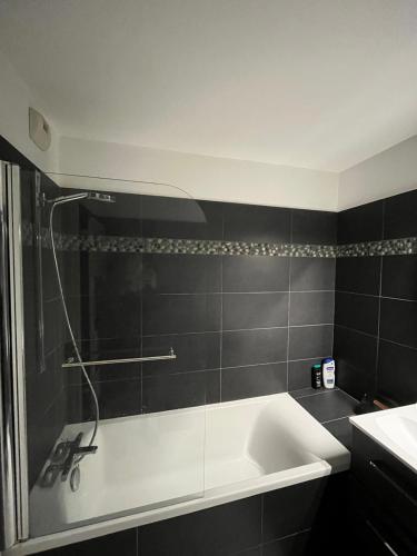 a bathroom with a bath tub and a sink at Appartement moderne et agréable, idéalement placé pour JO 2024 in Puteaux