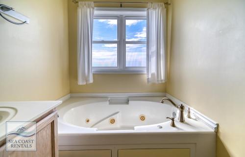 a bath tub in a bathroom with a window at Paradiso a Mare in North Topsail Beach