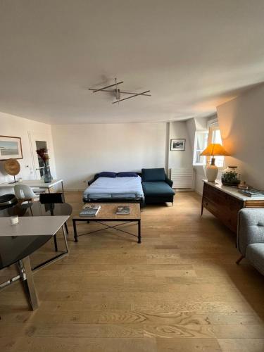 a living room with a bed and a couch at Appartement moderne et agréable, idéalement placé pour JO 2024 in Puteaux