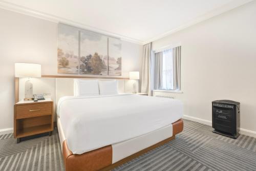a bedroom with a large white bed and a window at Capital Hilton in Washington