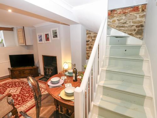 a dining room with a table and a staircase at 5A Castle Street in Ryde
