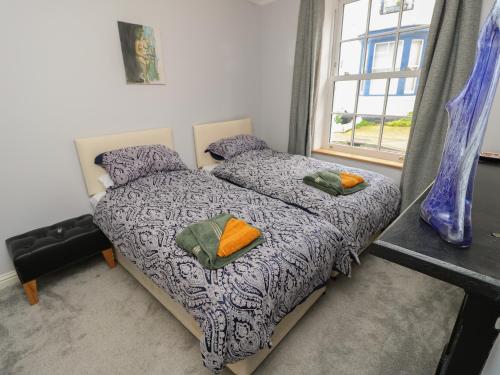 a bedroom with a bed with two pillows and a window at 5A Castle Street in Ryde
