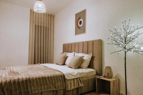 una camera con un letto e un albero di Boho Nest Apartment Prishtina a Pristina