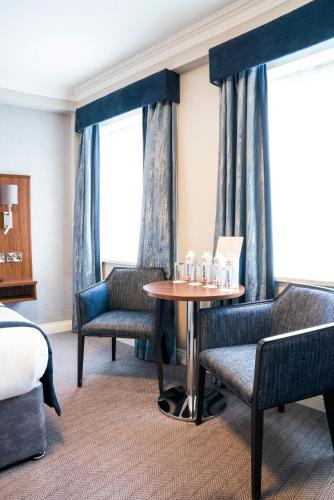 a hotel room with a bed and a table and chairs at The Western Hotel in Galway