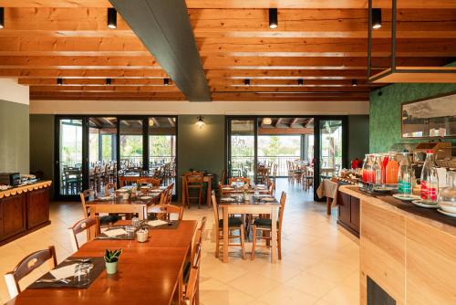a restaurant with wooden ceilings and tables and chairs at Agriturismo dei Grippi in Sona
