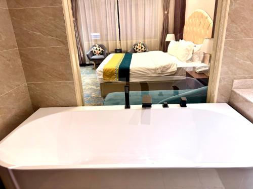 a room with two beds and a tub in it at 怡程酒店ECHENG HOTEL in Sihanoukville