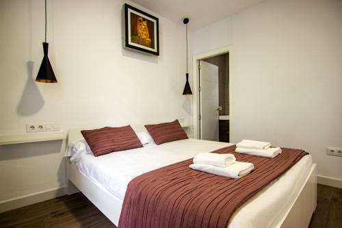 1 dormitorio con 1 cama con 2 toallas en RentalSevilla en Triana, en Sevilla