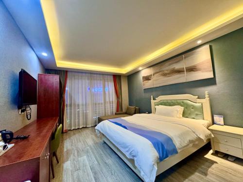 a bedroom with a bed and a desk and a television at 怡程酒店ECHENG HOTEL in Sihanoukville