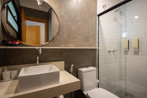 W łazience znajduje się umywalka, toaleta i lustro. w obiekcie Pousada Naturalia w mieście Abraão