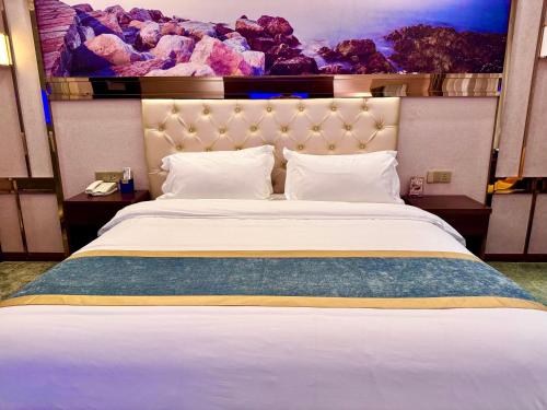 a bedroom with a large white bed with a large screen at 怡程酒店ECHENG HOTEL in Sihanoukville