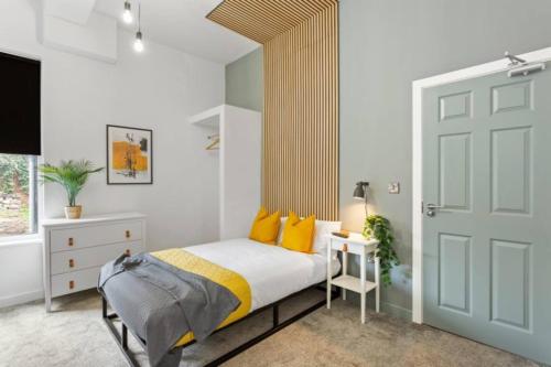 una camera da letto con letto e cuscini gialli di Nottingham Group Stay - 8 x Studio Apartments, sleeps 16, Free Parking a Nottingham