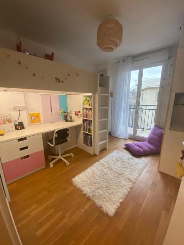 Cette chambre pour enfants dispose d'un bureau et d'une fenêtre. dans l'établissement Chaleureux et lumineux appartement, à Puteaux