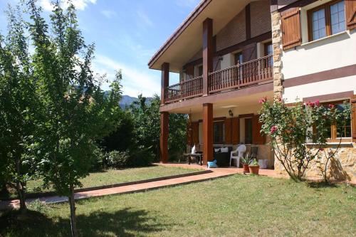 een huis met een tuin met een boom ervoor bij VILLASANA Naturaleza cerca de Bilbao in Villasana de Mena