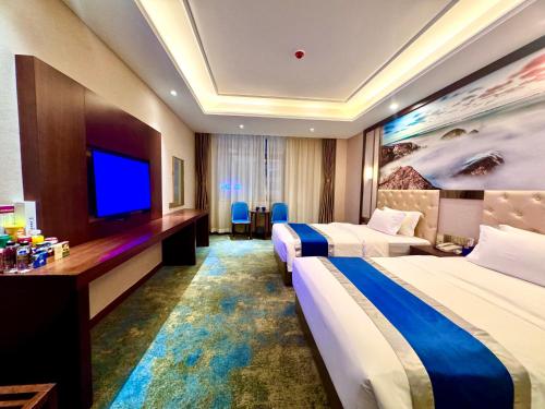 a hotel room with two beds and a flat screen tv at 怡程酒店ECHENG HOTEL in Sihanoukville