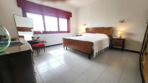 Un dormitorio con una cama grande y una ventana en Villa Isola Bella - Appartamento Vintage, en Mògoro
