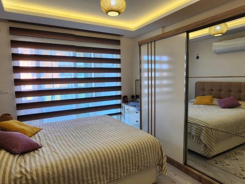 een slaapkamer met 2 bedden en een spiegel bij Cozy Sea view next to the beach, in the mid of the market, Saturday bazar, restaurants & bars etc, Alanya Mahmutlar! in Alanya