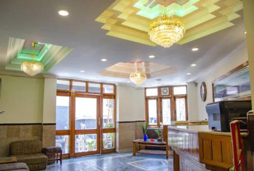 a living room with two chandeliers on the ceiling at Hotel Abhinandan Mussoorie Near Mall Road - Parking Facilities & Prime Location - Best Hotel in Mussoorie in Mussoorie
