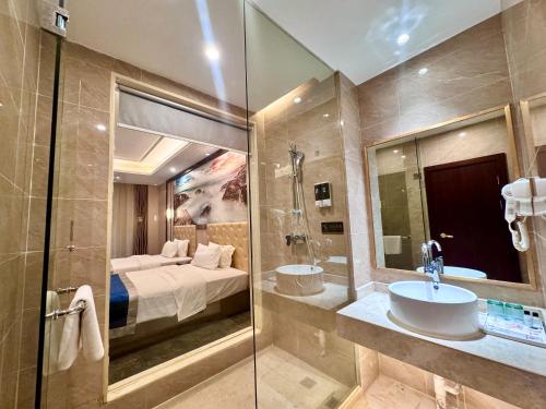a bathroom with a sink and a bed and a mirror at 怡程酒店ECHENG HOTEL in Sihanoukville