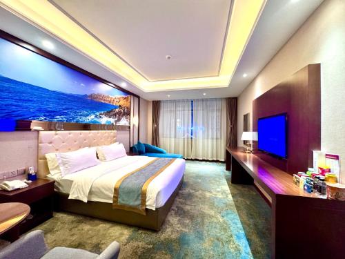 a hotel room with a bed and a flat screen tv at 怡程酒店ECHENG HOTEL in Sihanoukville