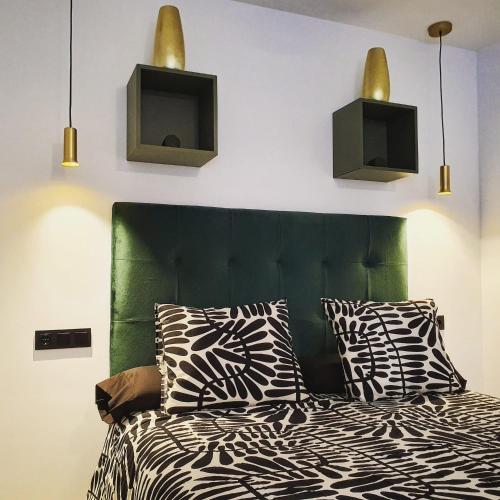 a bedroom with a bed with a green headboard at El Rincón de Eva II in Salamanca