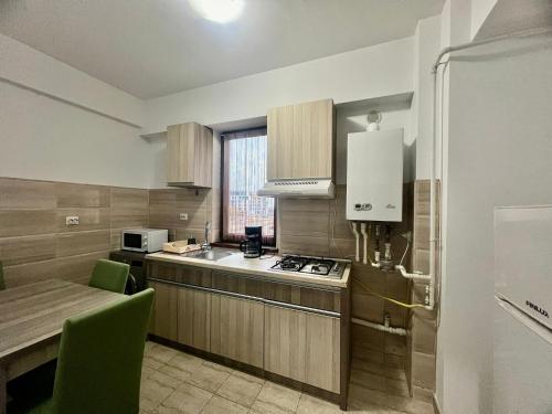 a kitchen with a counter and a table and a microwave at Summerland Apartmants mamaia nord in Mamaia