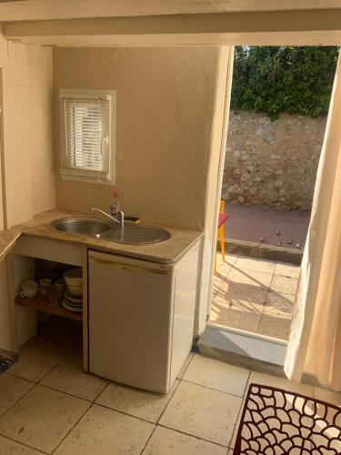 uma cozinha com um lavatório e uma porta aberta em Plus belle la vie ici em Marselha