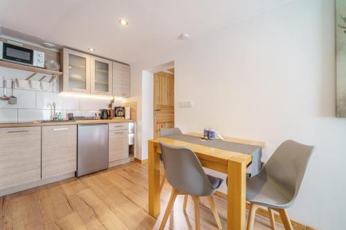 a kitchen with a wooden table and chairs at Ferienwohnungen Haselhuhn in Hartau