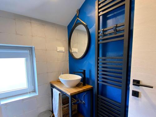 a blue bathroom with a sink and a mirror at Blue Horizon Apartment in Jadranovo