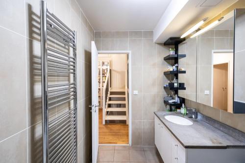 uma casa de banho com um lavatório, um espelho e uma escada em Villa Le Saint-Charles em Paris