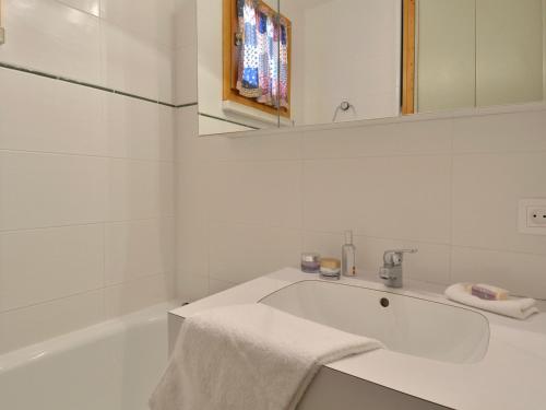 La salle de bains blanche est pourvue d'un lavabo et d'une baignoire. dans l'établissement Appartement Belle Plagne, 2 pièces, 5 personnes - FR-1-181-2261, à La Plagne Tarentaise