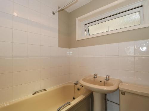 a bathroom with a sink and a bath tub at 27 Fernhill Heights in Bridport