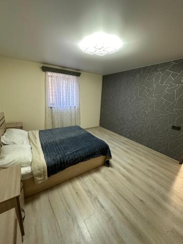 a bedroom with a bed and a wall at Zvartnoc House in Ejmiatsin