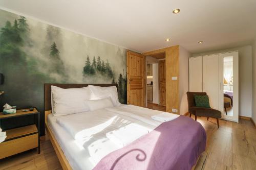 a bedroom with a bed with a painting on the wall at Ferienwohnungen Haselhuhn in Hartau