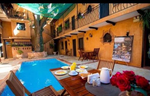 a patio with a table and a swimming pool at Boutique Colonial House Hotel in Santo Domingo