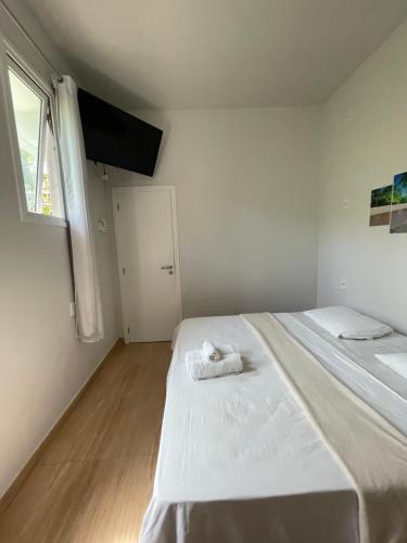 a white room with two beds and a window at Hospedaje MorroSP in Morro de São Paulo