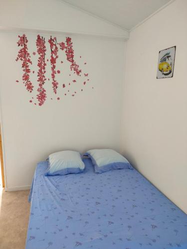- une chambre avec un lit orné de fleurs sur le mur dans l'établissement Grand studio centre ville Bretignolles, à Bretignolles-sur-Mer