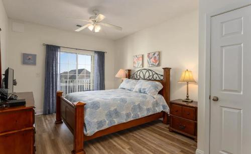 a bedroom with a bed with a ceiling fan and a window at Stunning and Spacious 5 BR Condo- With Ocean Views and more! Cherry Grove Villas 402 in Myrtle Beach