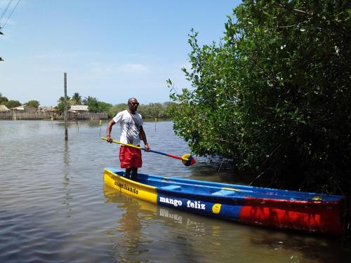 a man is rowing a boat in the water at Eco-Camping Mango Feliz Rincón del Mar in San Onofre