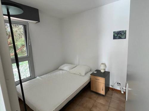 ein kleines Schlafzimmer mit einem Bett und einem Fenster in der Unterkunft Appartement Bormes-les-Mimosas, 2 pièces, 4 personnes - FR-1-610-99 in Bormes-les-Mimosas