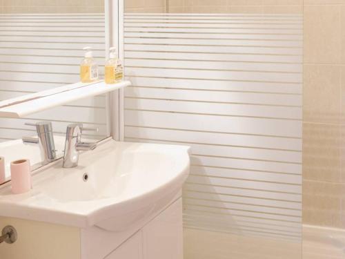ein weißes Badezimmer mit einem Waschbecken und einem Spiegel in der Unterkunft Appartement Bormes-les-Mimosas, 2 pièces, 4 personnes - FR-1-610-99 in Bormes-les-Mimosas