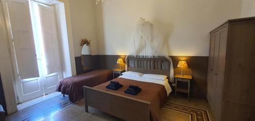 a bedroom with a bed and two lamps and a window at Affittacamere Museo in Taranto