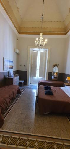 a large bedroom with two beds and a chandelier at Affittacamere Museo in Taranto